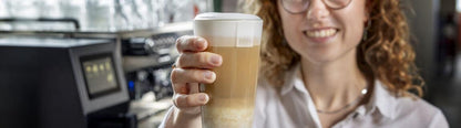 Barista met melkschuim bereid met de ETNA Alpina MilkBase
